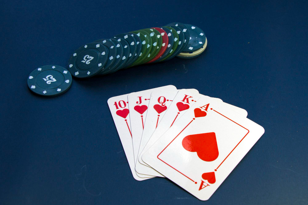 Royal flush set of cards with casino chips put on a playing table